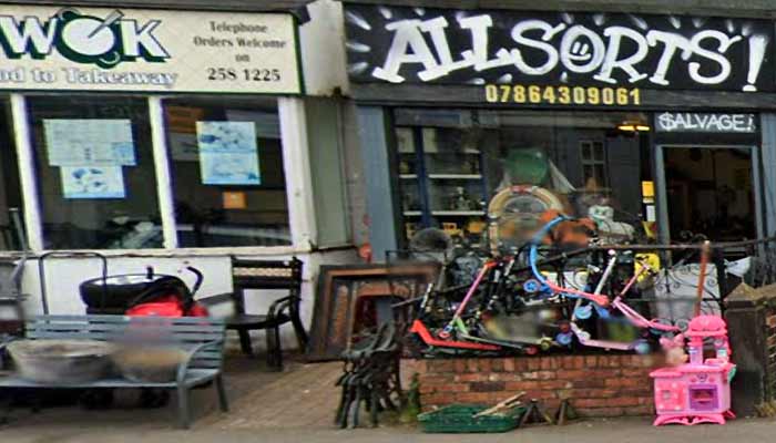 outside photo of the front of all sorts shop painted in in dark grey with a bright light green logo